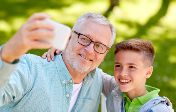 old man and boy taking selfie by smartphone